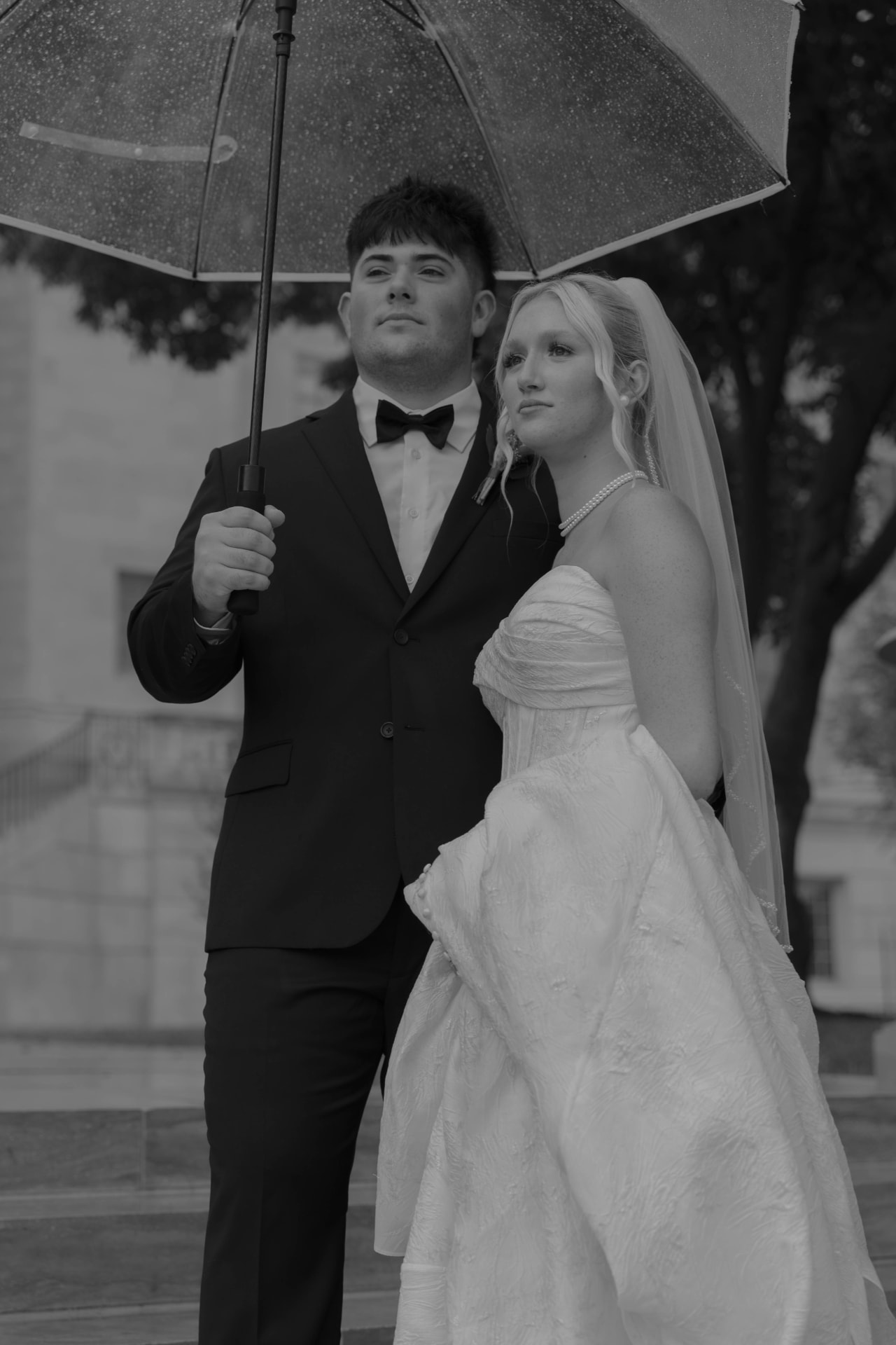Black and white rainy day wedding portrait of a couple under an umbrella in Columbia, Missouri